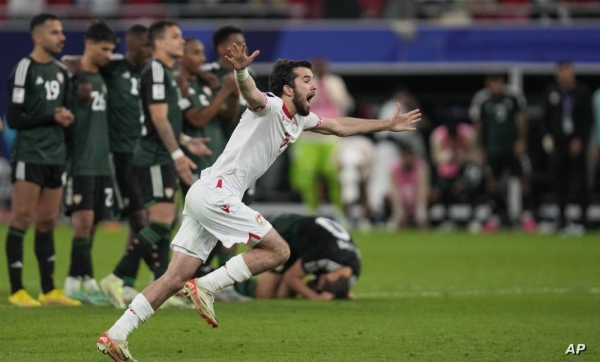 Tajikistan players celebrate after Tajikistan's Alisher Shukurov scores the winning penalty in a penalty shootout at the end of the the Asian Cup Round of 16 soccer match between Tajikistan and United Arab Emirates, at Ahmad Bin Ali Stadium, in Al Rayyan, Qatar, Sunday, Jan. 28, 2024. (AP Photo/Thanassis Stavrakis)
