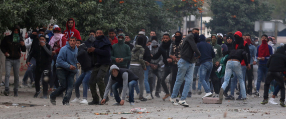 Protesters throw stones during demonstrations against rising prices and tax increases, in Tebourba