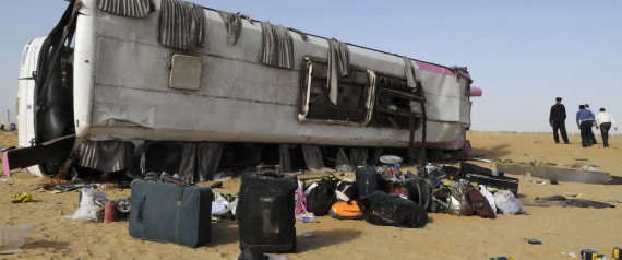 A policeman stands next to the wreckage of a bus in El Faiyum
