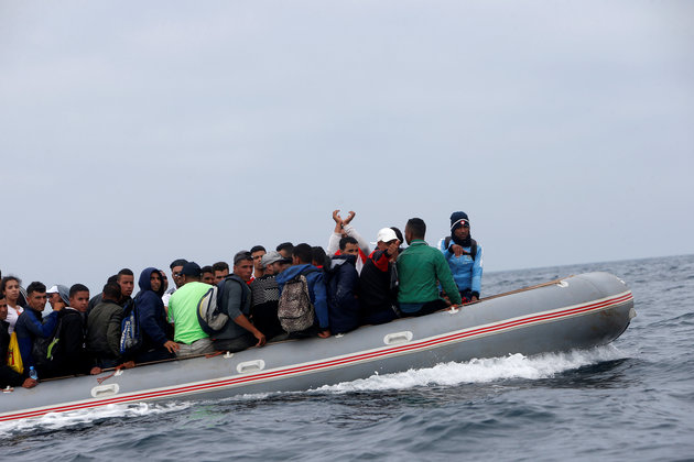 Migrants are seen before disembarking from a dinghy at Del Canuelo beach as they cross the Strait of Gibraltar sailing from the coast of Morocco, in Tarifa