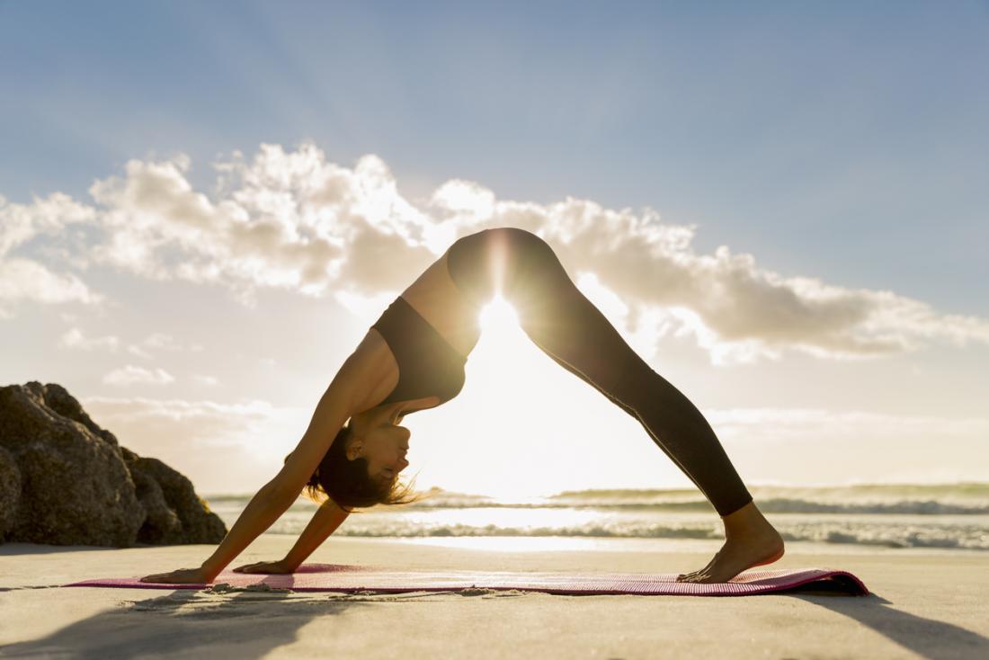 a-woman-practicing-yoga-on-the-beach