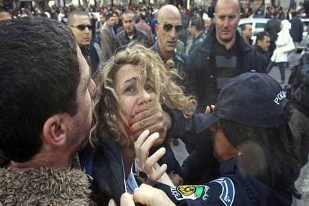 Police detain a protester during a demonstration against Algerian President Abdulaziz Bouteflika's decision to run for a fourth term, in Algiers