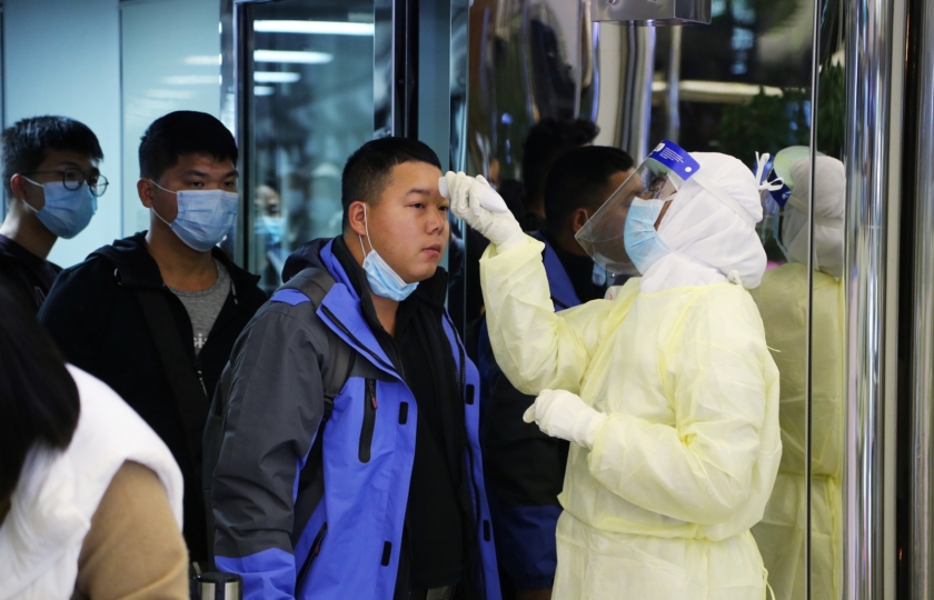 Passengers from China wearing masks to prevent a new coronavirus are checked by Saudi Health Ministry employees upon their arrival at King Khalid International Airport, in Riyadh