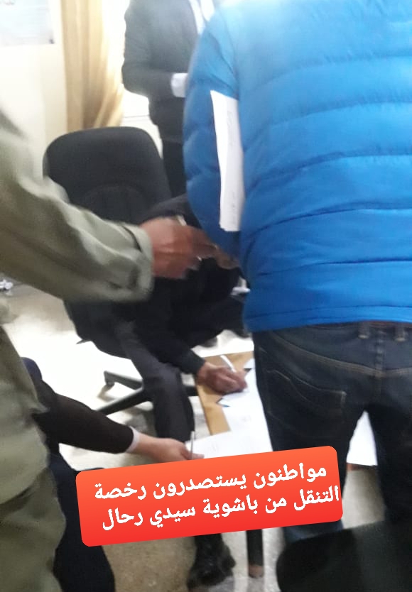 صورة لتحلق المواطنين حول الموظف المكلف لاستصدار ترخيص التنقل